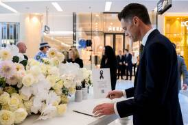 NSW Premier Chris Minns signs a condolence book whilst visiting a memorial to the victims who lost their lives in Saturdays knife attack at Westfield Bondi Junction shopping centre. Photo by AAP Image/Bianca De Marchi