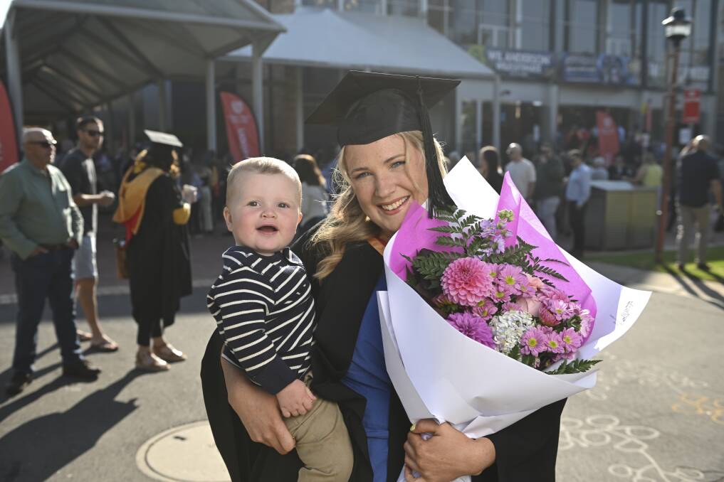 Molly Keough with nephew Hugh Chivell, 1 of Wagga, before celebrating her achievements with her family after the ceremony. Picture by Mark Jesser