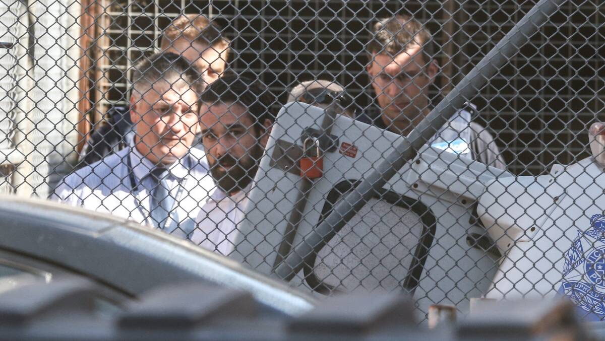 ACCUSED: Bowe Madigan is led into a vehicle by police officers outside Wangaratta Magistrate's Court. Picture: MARK JESSER