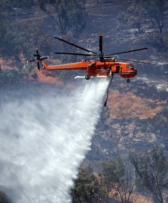 ACTION: An Erickson Air-Crane helicopter drops water onto a bushfire west of Wodonga last December. Picture: MATTHEW SMITHWICK