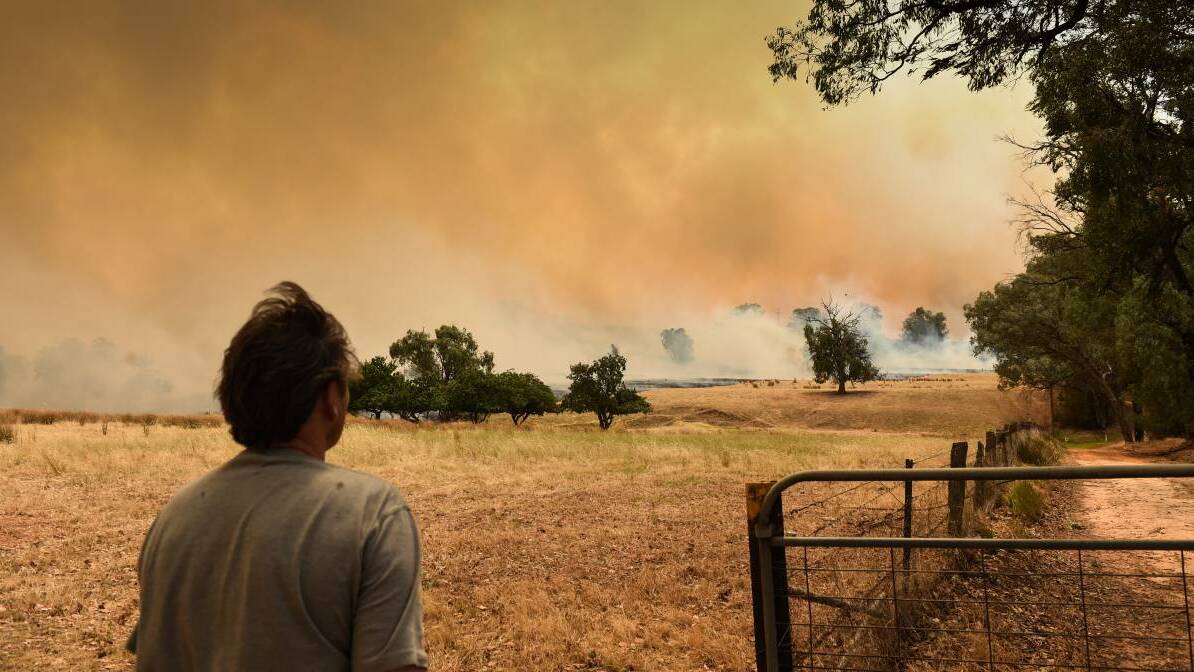 A residents looks on in dismay at the fires. Picture: ELENOR TEDENBORG
