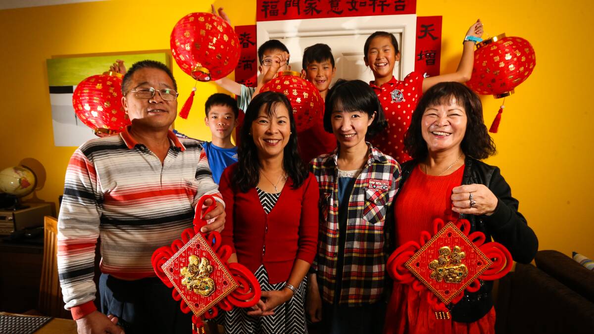 CHEEKY MONKEY: Nicole Ching, and her family from Taiwan, prepare for the Chinese New Year with traditional decorations. Picture: JAMES WILTSHIRE