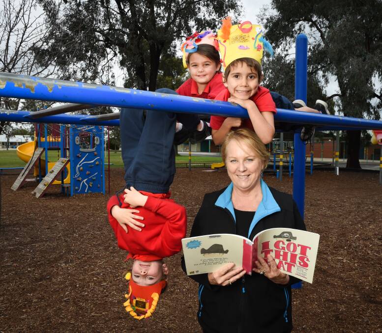 HATS ON: Albury North Public School teacher/librarian Liz Dick hangs out with kindergarten students Macy Elias, Kiesha Kennedy and Jaelin Moren, all 5, for National Simultaneous Storytime on Wednesday. Picture: MARK JESSER