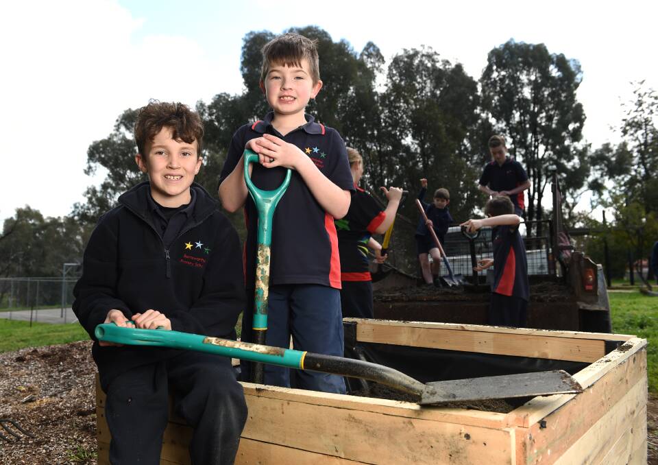 TEAM WORK: Barnawartha Primary pupils William Pitts and Ty Klippel lend a hand to plant the vegie garden donated under the Healthy Eating in Schools program.