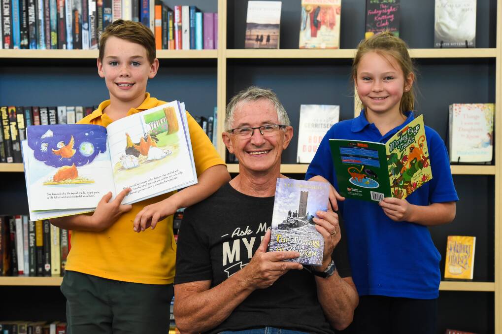 PAGE-TURNER: Author Ian Trevaskis launches The Towers of Zordran, with Henry Lord, 10, St Michael's Primary, and Erin Dodd, 10, Tallangatta Primary. Picture: MARK JESSER