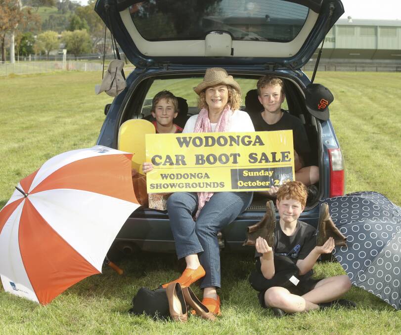 FULL LOAD: Kathy Gilchrist with her sons Ryan, 10, Trent, 13, and Aidan, 10, (seated), prepare for the Wodonga Car Boot Sale on Sunday. Picture: ELENOR TEDENBORG