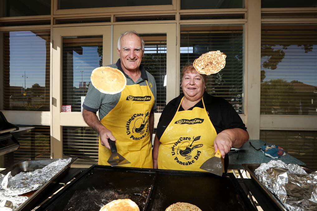 AIR SWING: Dennis Martin and Donna McPherson cook sweet and savoury pancakes at St Stephen's Uniting Church. Picture: JAMES WILTSHIRE