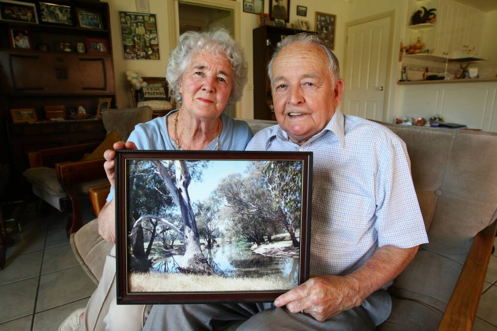Irene and Colin Margery, of Wodonga, who lived through the 1952 bushfires in Barnawartha, which came through on January 31. The couple were married on April 19 the same year. They hold a picture of their Barnawartha property.