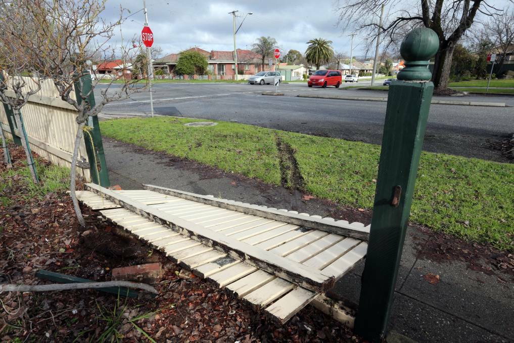 SMASHED: The front fence of this Olive Street home was damaged in the car crash. Picture: PETER MERKESTEYN