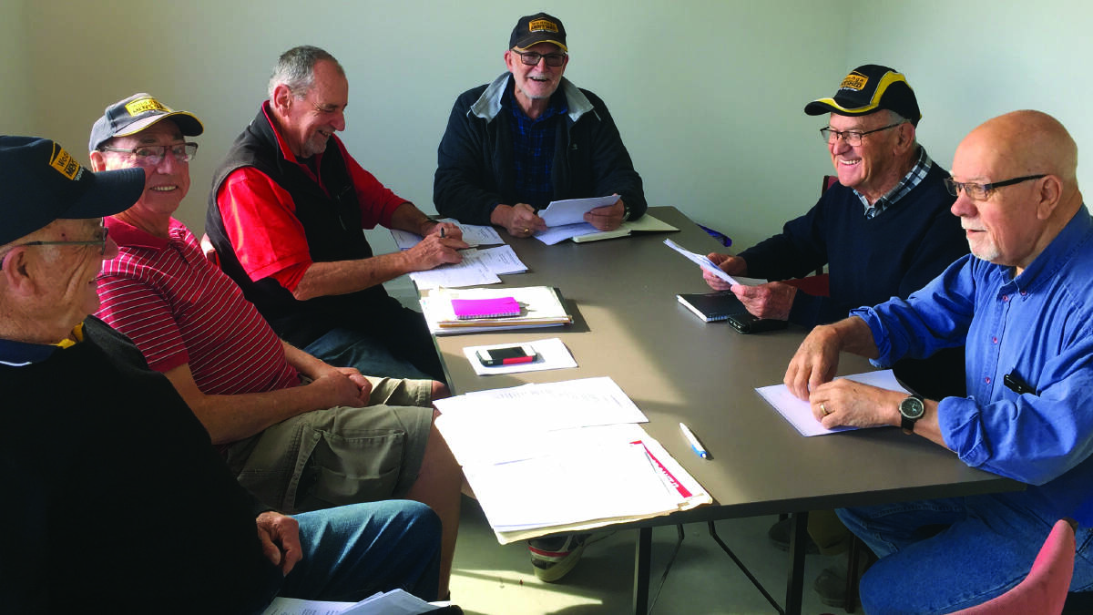 Malcolm Gillies (centre) donates time at the Men’s Shed, a location focused on offering a welcoming forum for men to discuss health and well-being.
