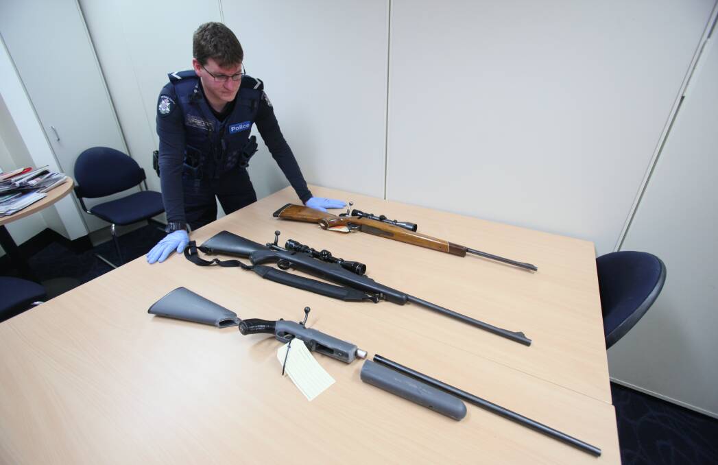 BACK IN SAFE HANDS: Constable Brendon Gordon with three stolen high powered rifles, one of which had been shortened.