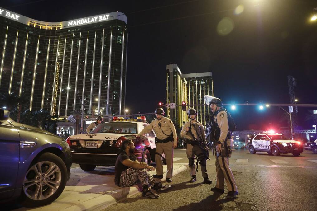 TRAGEDY: Police officers stand at the scene of a shooting near the Mandalay Bay resort and casino on the Las Vegas Strip. Multiple victims were being transported to hospitals.