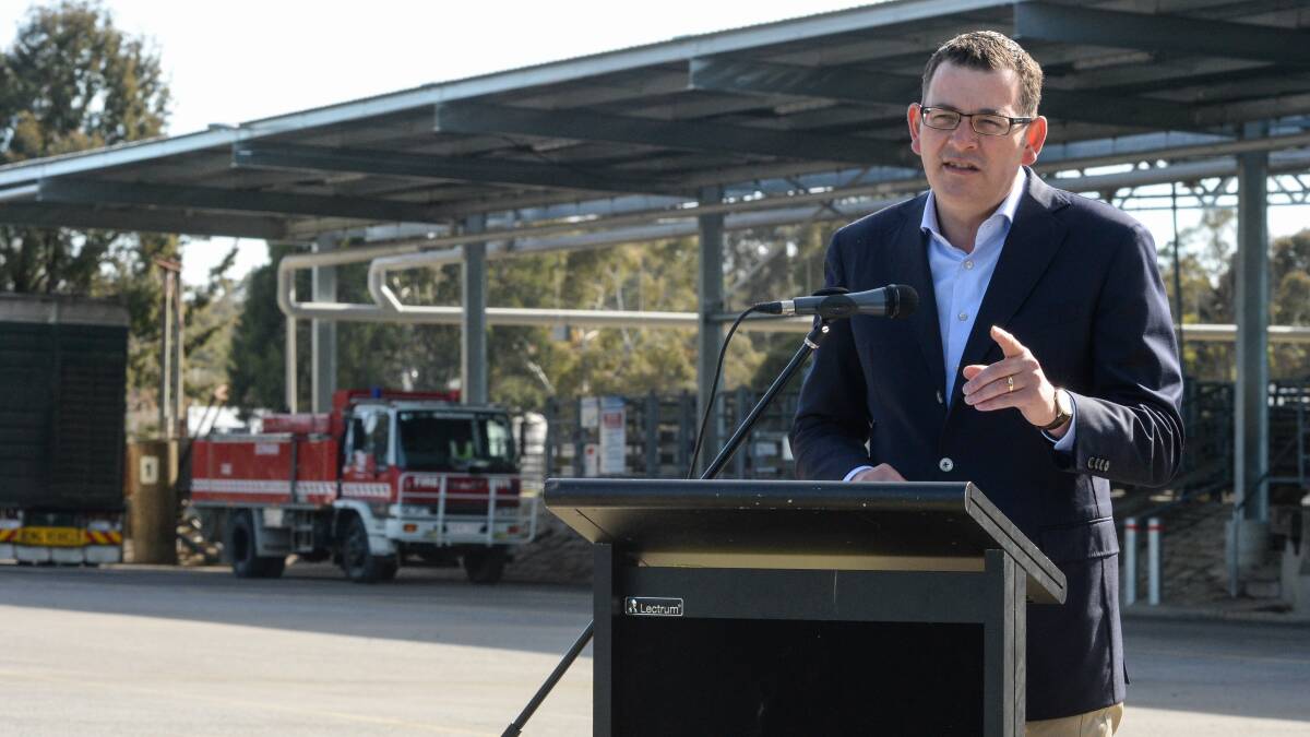 LOOK BEHIND YOU: The Boorhaman fire truck watched over Premier Daniel Andrews at Wangaratta Saleyards on Thursday. Pictures: MARK JESSER