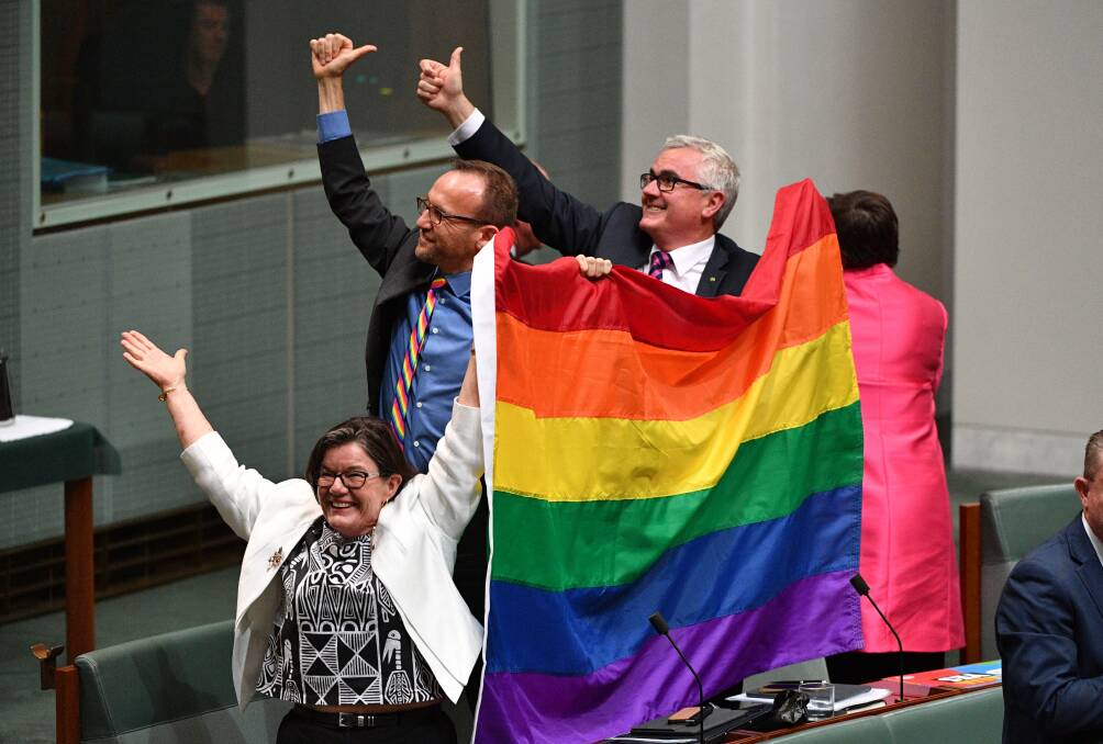 LOVE WINS: Cathy McGowan, Adam Brandt and Andrew Wilkie celebrate the passing of the Marriage Amendment Bill in the House of Representatives. Picture: MICK TSIKAS
