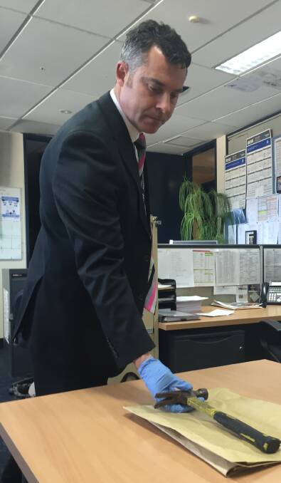 WEAPON: Detective Sergeant Graeme Simpfendorfer with the hammer believed to have been used as a weapon in an aggravated burglary.