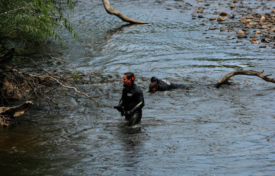 GRIM SEARCH: Police divers scour the Ovens River in Whorouly on Sunday. Picture: MARK JESSER