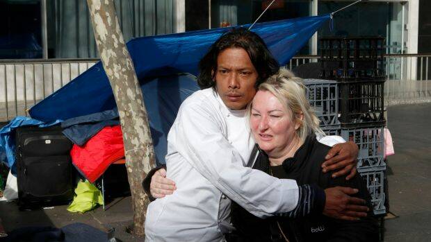 Residents of the Martin Place tent city embrace before packing up. Photo: Daniel Munoz
