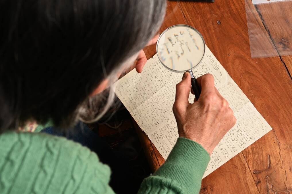 PRIDE: Honor Auchinleck, the daughter of Tom and Elyne Mitchell, uses a magnifying glass to read letters between her father and his mother, Winifred, after Victory in the Pacific.