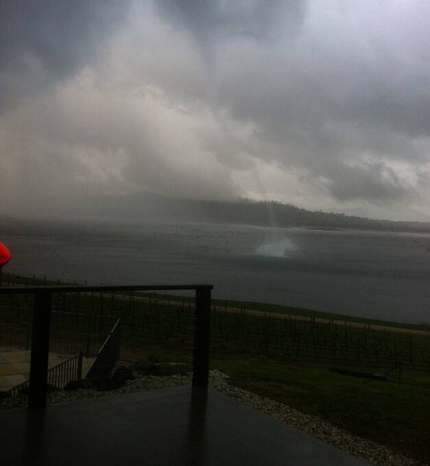 WILD WEATHER: A small tornado draws water from the surface of the Hume Weir, causing a waterspout on Friday. Bureau of Meteorology duty forecaster Stuart Coombes was tracking the storm. Picture: AMY SWINNERTON 
