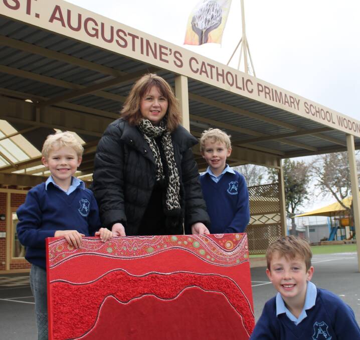 EXCITED: St Augustine's students Darcy Lockhart, 6, Tommy Lockhart, 7, and Oliver Keene, 8, are preparing for this year's competition with last year's triumphant winner, Helen Pynta. Picture: CLAIRE KILLEEN