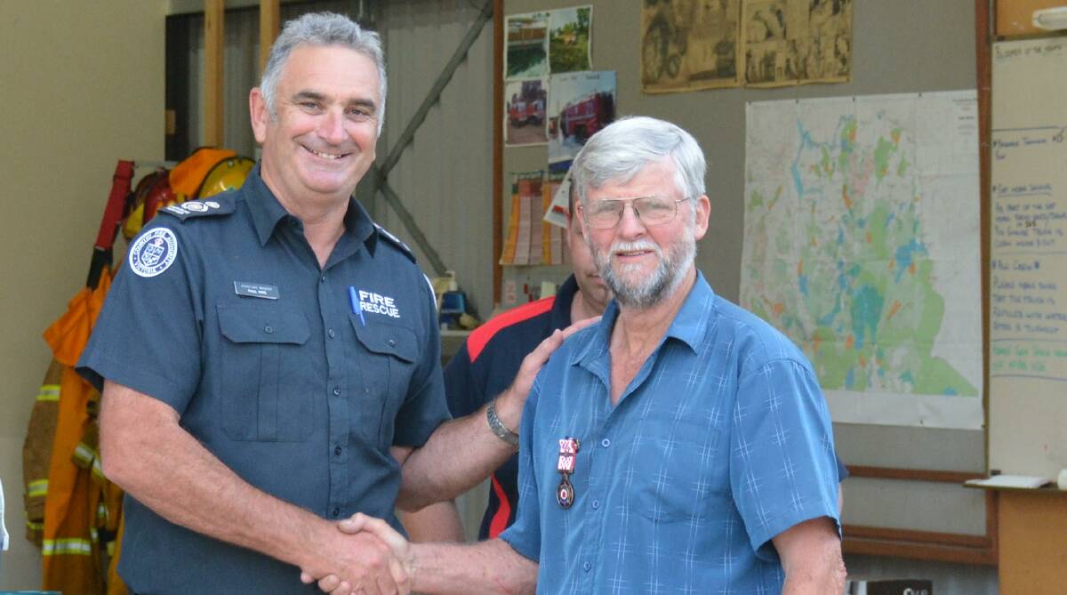 HONOUR: Wodonga-based CFA operations manager Paul King awards Max Bowran a medal for his 55 years of service to Allan's Flat CFA at a barbecue on Friday night.