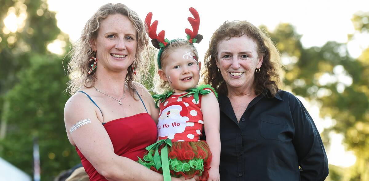 TRIO: Celeste Dobson, Danika Paige, 2, and Sue Cherry were among up to 10,000 people who attended the 40th annual Carols by Candlelight in Wodonga on Sunday evening.