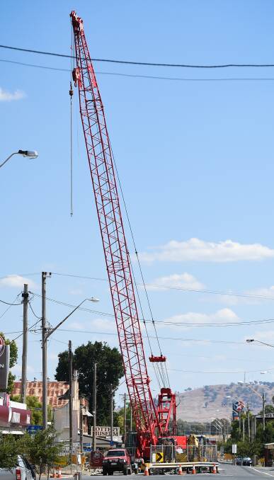 BIG RED: A massive crane undertakes bridge works over Ten Mile Creek on Albury Street in Holbrook's CBD before an expected finish in late March. Pictures: MARK JESSER