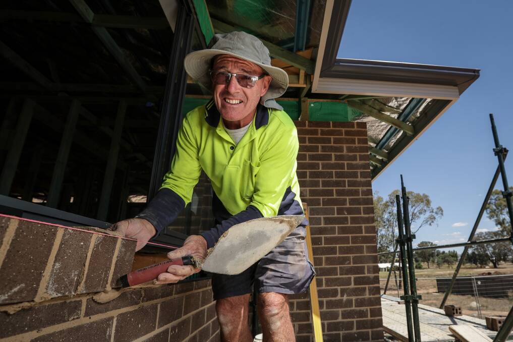 STRONG FOUNDATIONS: Bricklayer Graham McAuliffe recently finalising some work on the house being built to raise money for popular sportsman Nick Dempsey, who broke his neck in a diving accident. Picture: JAMES WILTSHIRE