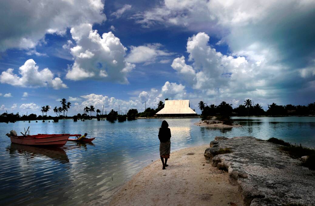 UNDER THREAT:  Climate change and rising sea levels in Kiribati Islands in the Pacific ocean are forcing the relocation of villages. This community hall is protected by sand bag sea walls. Picture: JUSTIN McMANUS