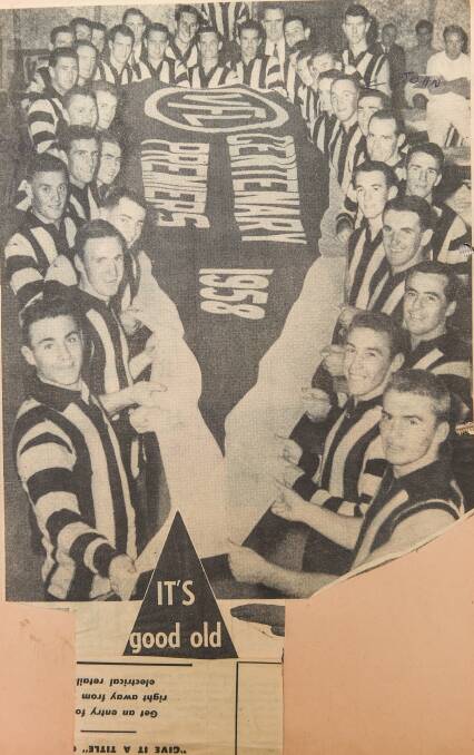 Collingwood players show off the 1958 premiership flag.