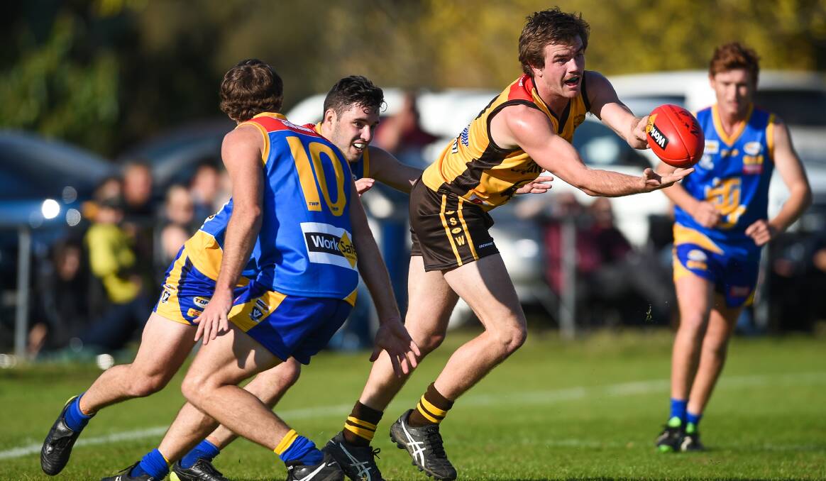ON THE MOVE: Hume's Jed Andrew dishes off a handball in the league's 70-point win over arch-rivals Tallangatta on Saturday. Pictures: MARK JESSER