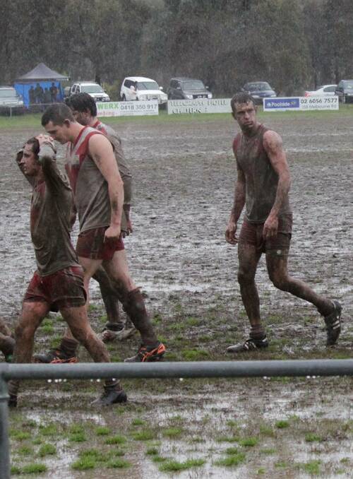 TOUGH GOING: Chiltern players trudge off the ground in the mud after playing minor premier Kiewa-Sandy Creek at Chiltern on August 1.