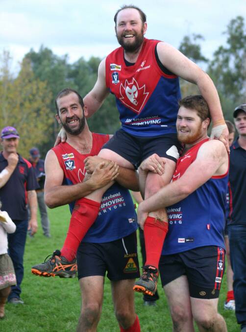 LEADING FROM THE FRONT: Corryong coach Evan Nicholas is chaired off the ground by teammates Dan McInnes and Jarrod Cass after his 200th match on Saturday. The Demons defeated Tumbarumba by 36 points. Picture: DEB HARRAP