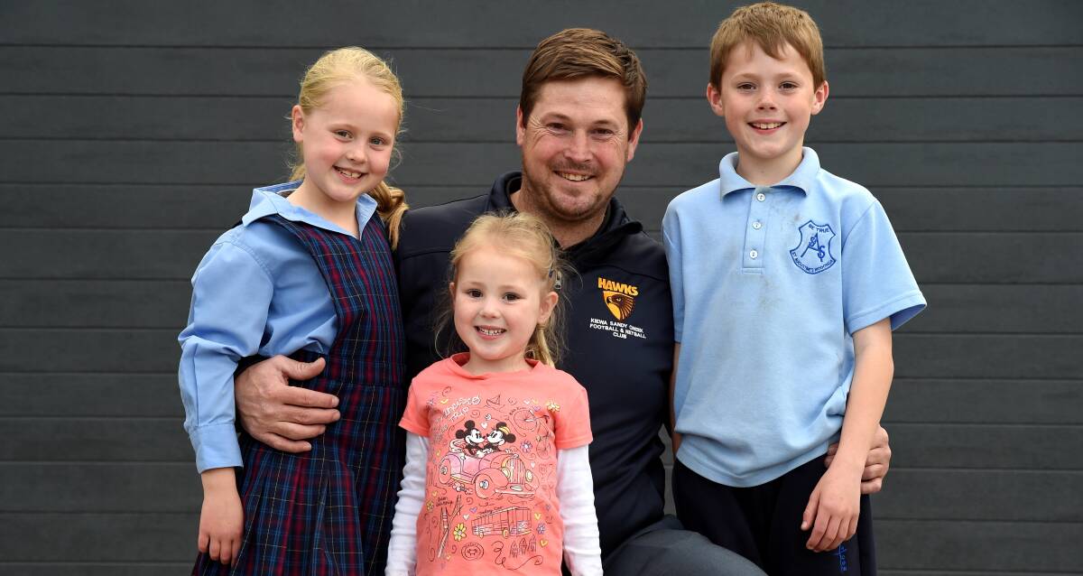 FAMILY MAN: New Kiewa-Sandy Creek coach Adam Mudra with his children Tully, 4, Scarlett, 7, and Louie, 9. He is excited by the Hawks prospects. Picture: MARK JESSER