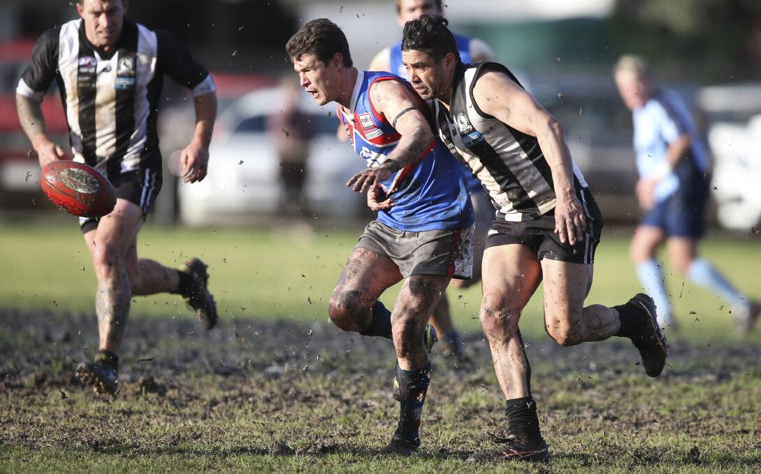 THE RACE IS ON: Jindera's Sam Crawshaw and Magpie Matt Murray charge through the mud at Urana Road Oval. Picture: ELENOR TEDENBORG