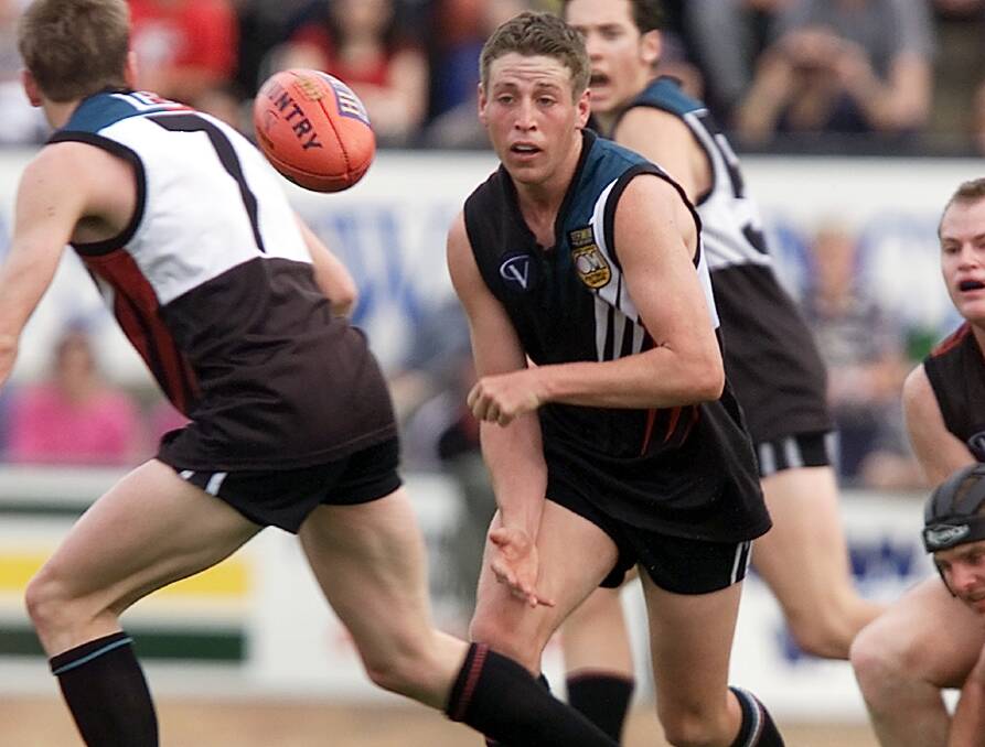 Pendergast fires out a handball to teammate John Hunt during the 2001 grand final against Myrtleford.