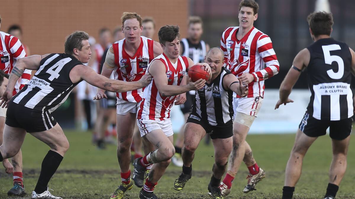 Swampie Hayden Singe clears the ball from a pack on Saturday. The midfielder was best afield in the thrilling win.