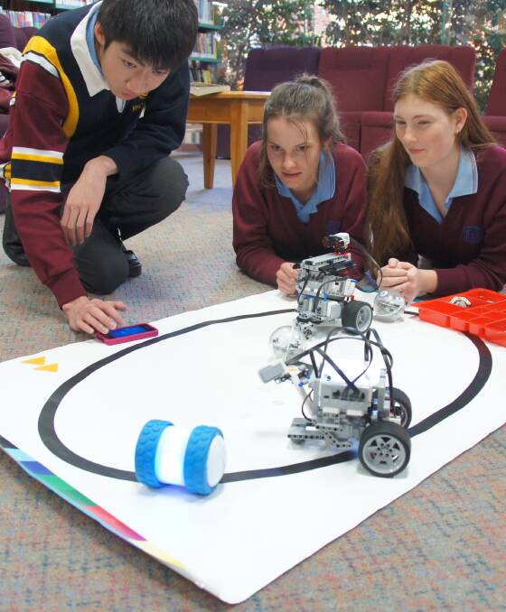 Galen students Richard Lai, Kate Jolly and Jemma Ryan play with ‘Ollie’, a smartphone controlled robot. 