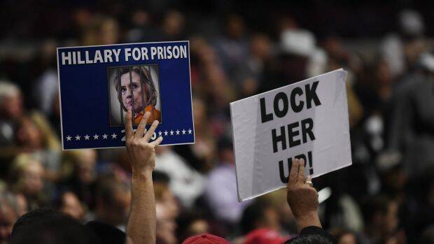 Delegates hold signs reading "Hillary For Prison" and "Lock Her Up" during the Republican National Convention in Cleveland in July. Photo: Bloomberg