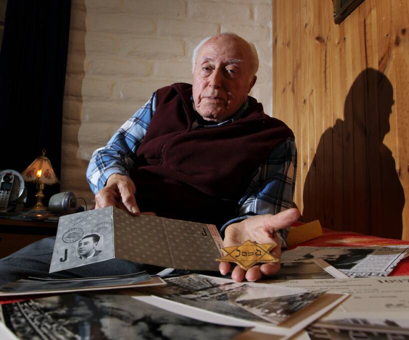 Remarkable life: Robert Hymans, pictured in 2013 at his Indigo Valley home, with his World War II identity card and Star of David badge he was forced to wear on a day-to-day basis by Nazis. 
