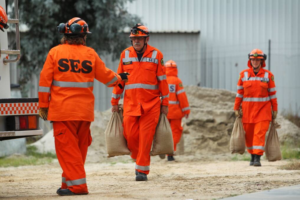 Top contributor: Kevin Kennedy prepares sandbags with fellow SES members during a flood emergency. He was named Albury's volunteer of the year during Australia Day celebrations at Noreuil Park.