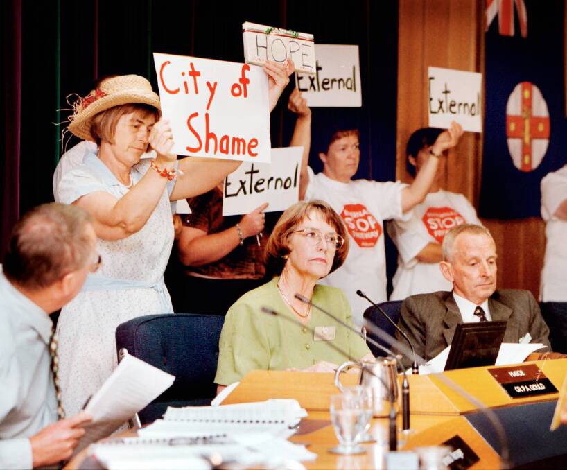 Flashback: Freeway protesters surround then Albury mayor Patricia Gould with placards at a 1998 council meeting. Under an Indigo Shire plan a person at a shire meeting who displays placards could be fined $750.