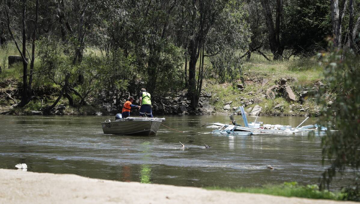 Still a mess: Police divers plunged into the Ovens River on Saturday afternoon to seek evidence related to a truck crash which has left a mass of rubbish in the waterway. Picture: JAMES WILTSHIRE