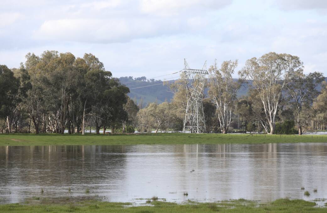 On the line: One of the transmission towers that run through West Wodonga near the quarry which has been inundated with flooding. Picture: ELENOR TEDENBORG
