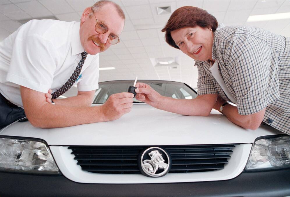 On the job: David Murray in 1998 at McRae White handing over the key to a Holden Vectra to competition winner Beverley Cottrell of Culcairn. 