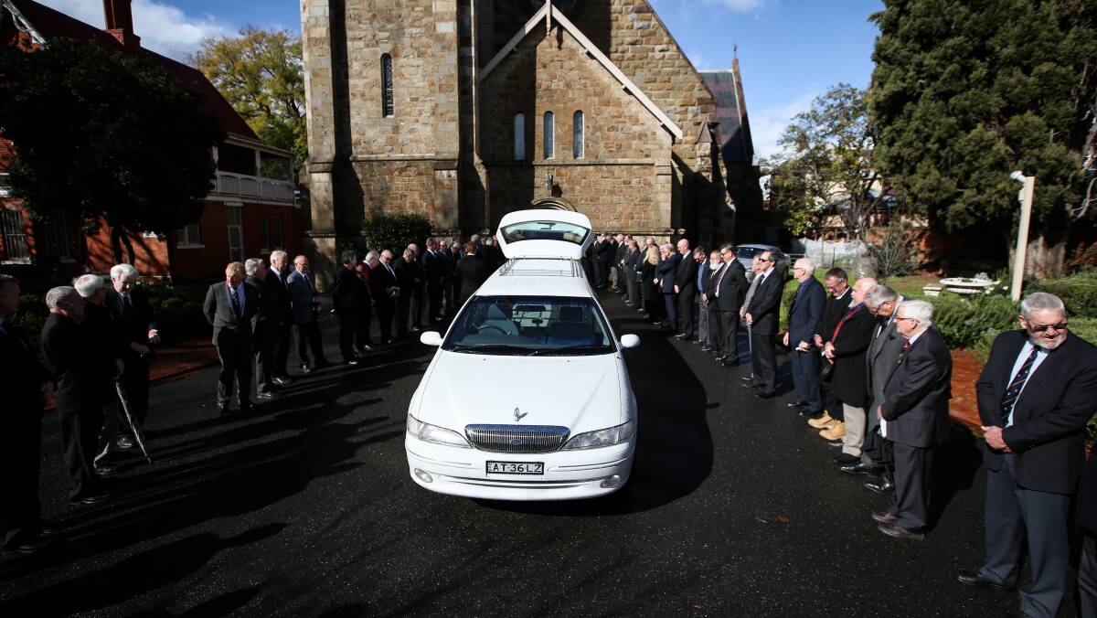 Club man: Rotary Club of Albury North members formed a guard of honour as Arch McLeish's coffin was brought from the church to the sounds of lone piper Lily Turner, a Scots School student.