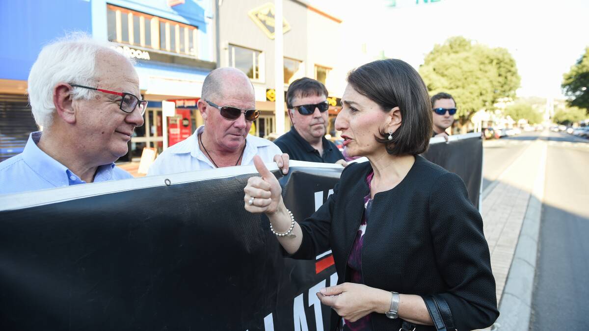 Making a point: IGA owner Bob Mathews listens as Gladys Berejiklian makes a point while they stand on the Dean Street median strip. Picture: MARK JESSER