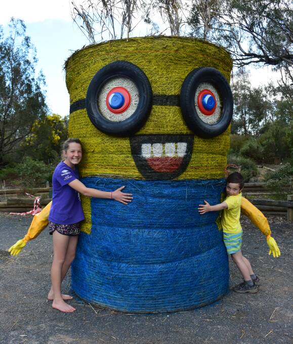Minion making hay: Burrumbuttock duo Ahlani Eddy, 14, and Oliver Donovan, 8, with the bales which have been turned into a Minion outside the Wirraminna environment centre. 