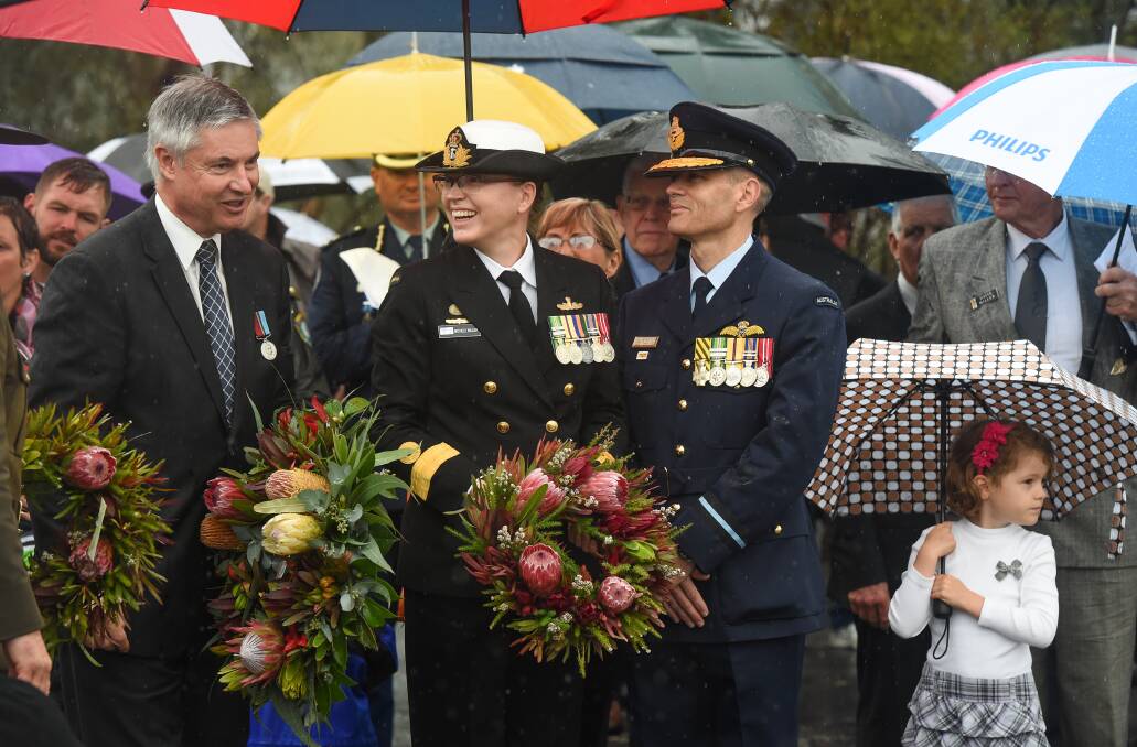 Candid moment: Member for Albury Greg Aplin with Commodore Michelle Miller and her husband Air Commodore Matt Hegarty and their daughter Madeline, 5, prepare to lay wreathes at the Albury war monument.