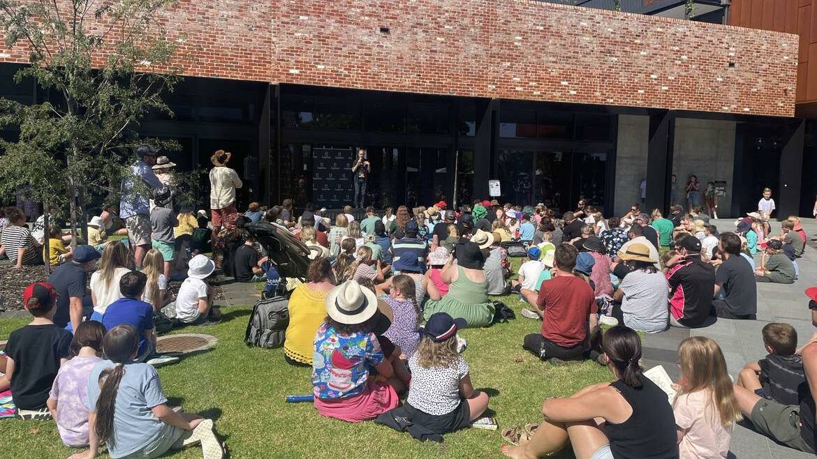 Children and their parents watch on as Andy Griffiths speaks to them outside the Wodonga library. Around 200 people attended the talk. 